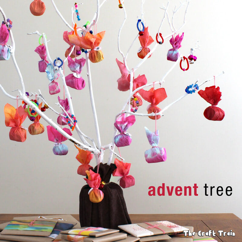 Advent tree calendar made from tie-dyed paper towel and painted branches. We also put a Christmas book advent calendar underneath