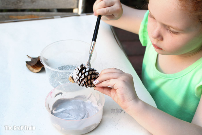 Child making a nature ornament for Christmas decorating