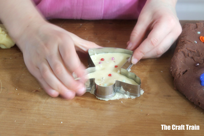 child making Christmas cookie from playdough