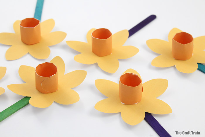 paper daffodils on a white background viewed from an angle