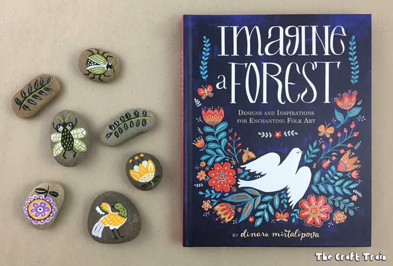 Rock painting inspired by traditional fold art from Imagine a Forest by Dinara Mirtalipova