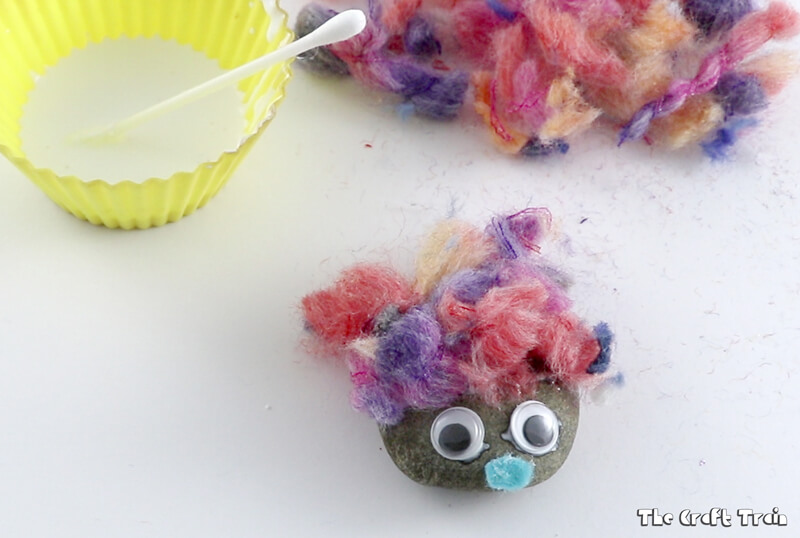 Create adorable fluffy rocks with yarn pom pom trimmings