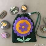 A fun rock painting craft inspired by traditional folk art. Store the rocks in a matching hand-sewn felt bag – with free printable pdf pattern