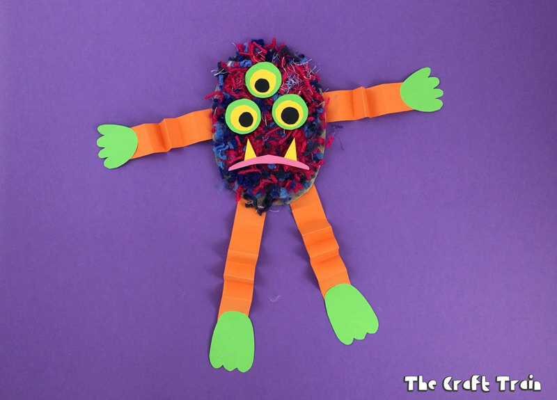 Easy fluffy yarn monster craft for kids made using pom pom trimmings