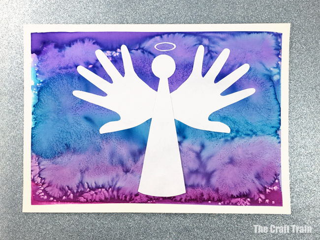 Christmas handprint art in peace dove, reindeer and angel designs. Create a process art background using liquid watercolour and salt, then use the printable template and handprint shapes to create the silhouette art #christmas #christmasart #handprint #handprintart #dove #peacedove #reindeer #angel