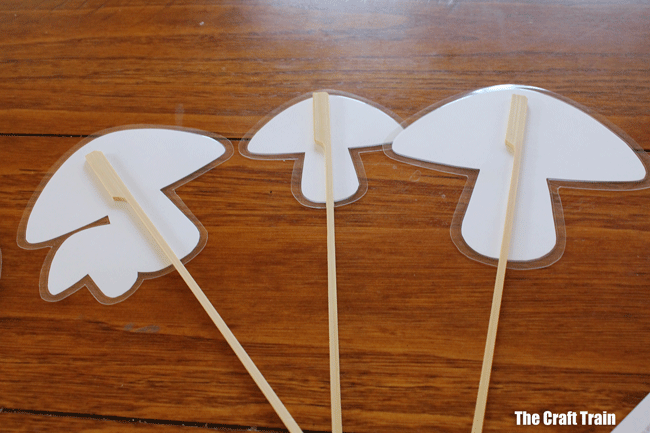 Place skewers on the back of the laminated mushrooms and poke them into the dirt in your fairy garden #outdoorfun #fairies #fairygarden #printable #fairyprintable #fairycrafts #printablecrafts #gardeningwithkids #fairies