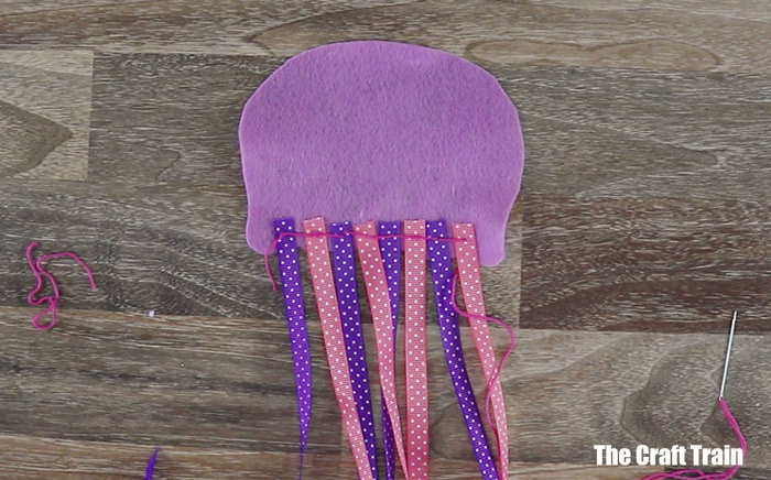 steps to make a jellyfish - sew the ribbon stingers into place