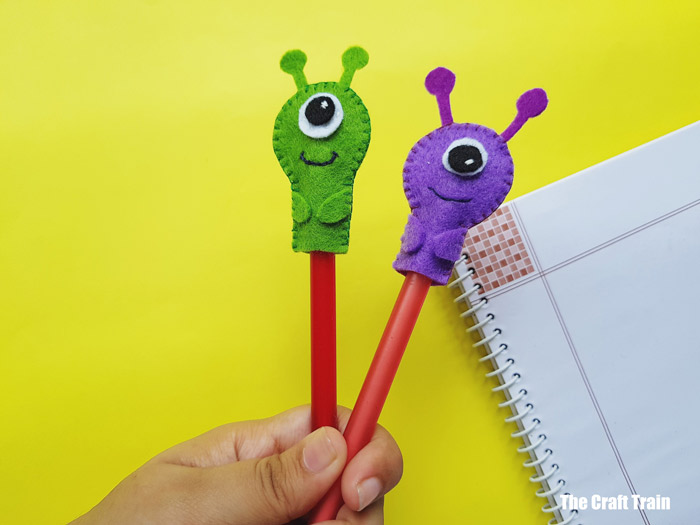 hand holding monster pencil toppers, an easy felt sewing project for kids