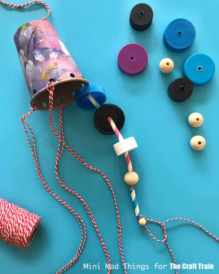 thread the bottle tops and sraws onto string