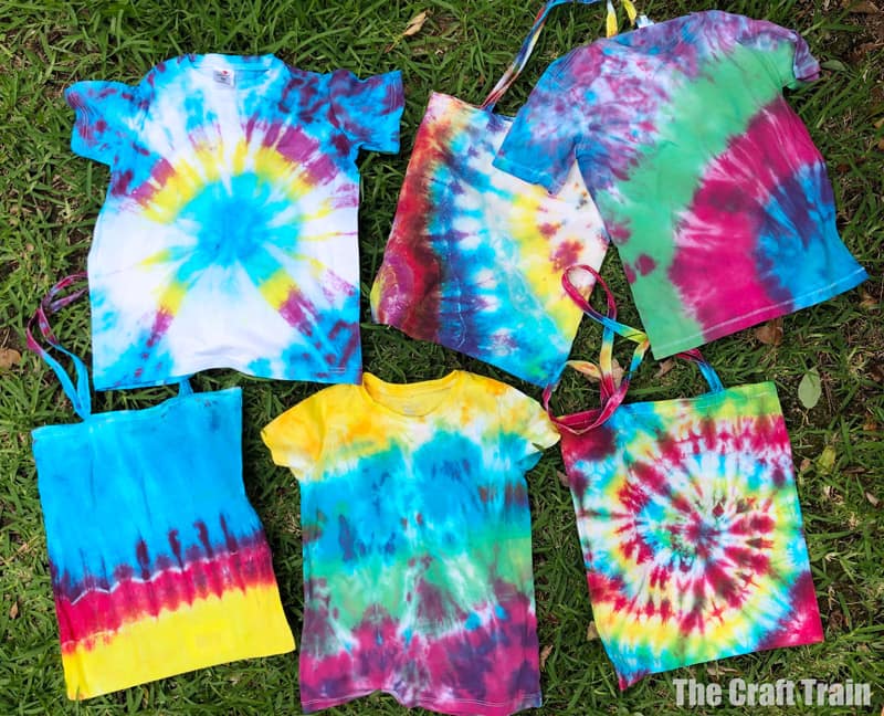 tie dye shirts and bags on grass